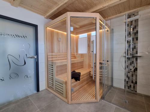a shower with a glass door in a room at WellnessOase Hafenblick in Walchum