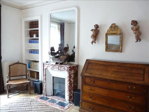 Cette chambre comprend une cheminée, un miroir et une commode. dans l'établissement Le Latin, à Paris