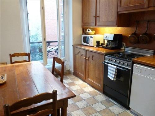 une cuisine avec une table et une cuisinière four supérieur dans l'établissement Le Latin, à Paris