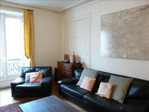 un salon avec un canapé en cuir noir et une table dans l'établissement Le Latin, à Paris