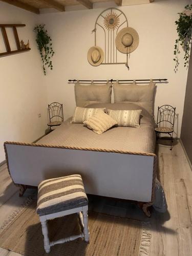 a bed in a room with a large bed with a chair at Maison de village 5 vacanciers chez Néné et Bibi in Roquemaure