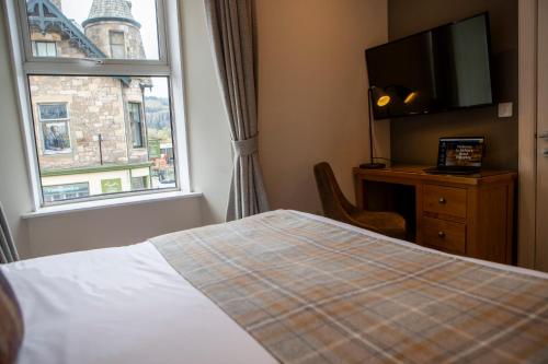 a hotel room with a bed and a window at McKays Hotel in Pitlochry