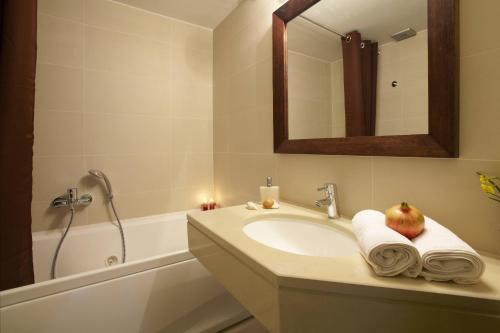 un baño con lavabo con una manzana encima en Ikia Luxury Homes, en Gonia
