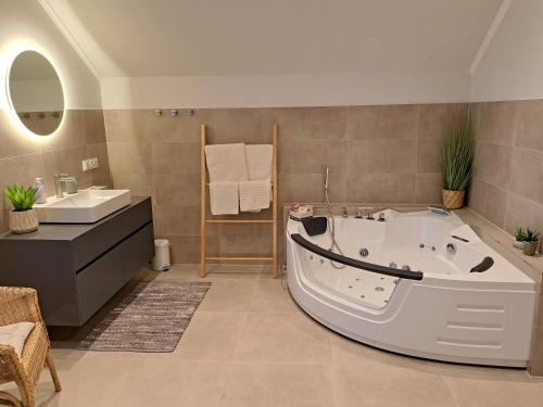 a bathroom with a tub and a sink at STRANDhaus28 in Walchum