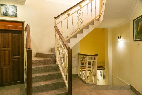 a winding staircase in a home with a wooden door at Zanzibar Town Nest Hotel in Zanzibar City