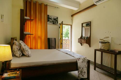 a bedroom with a bed with an orange curtain at Zanzibar Town Nest Hotel in Zanzibar City