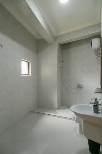a white bathroom with a sink and a shower at Zanzibar Town Nest Hotel in Zanzibar City