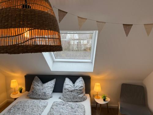 a bedroom with a bed with two pillows and a window at FeWo Hygge Hennstedt in Hennstedt