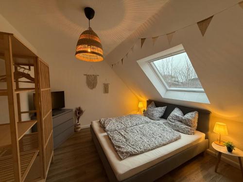 a attic bedroom with a bed and a window at FeWo Hygge Hennstedt in Hennstedt