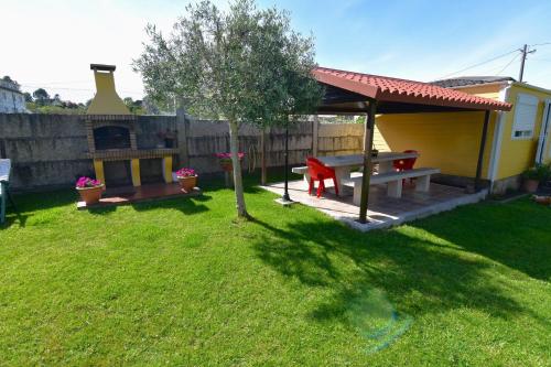 a backyard with a picnic table and a gazebo at Casa natural con cenador en jardín y parking in San Vicente do Mar
