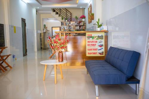 a living room with a blue couch and a table at Gold Stone Hoi An Homestay in Hoi An