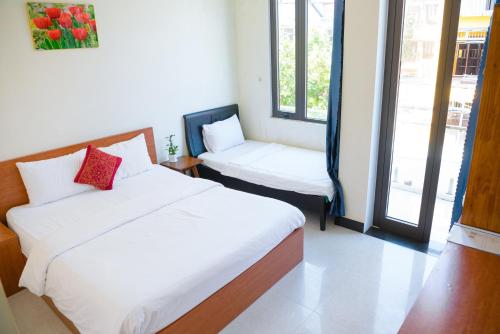 a hotel room with two beds and a window at Gold Stone Hoi An Homestay in Hoi An
