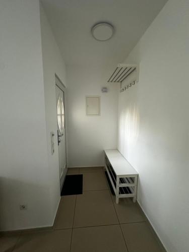an empty hallway with a white wall and a table at FEWO Lohmar in Lohmar