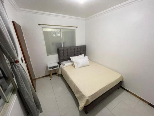 a small bedroom with a bed and a window at Apartamento independiente en casa familiar Fusagasugá in Fusagasuga