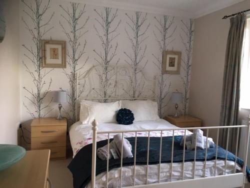 een slaapkamer met een bed met een blauw dekbed bij Heatherlea Holiday Cottage in Otterburn