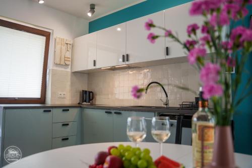 a kitchen with a table with wine glasses and flowers at Przy Rozlewisku in Sarbinowo