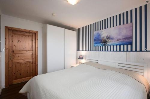 a bedroom with a white bed and a striped wall at Neustein 07 in Stein