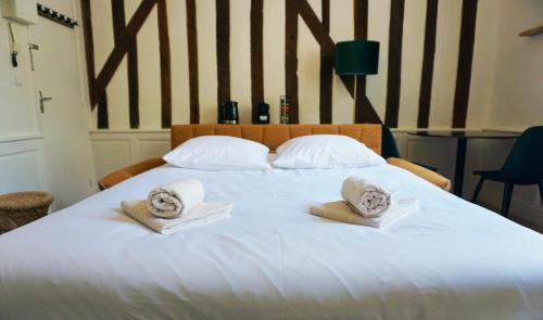 un lit blanc avec des serviettes et des oreillers dessus dans l'établissement Charmant studio à deux pas de la gare, à Tours