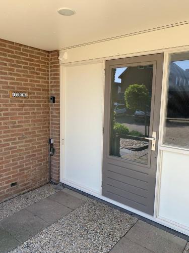 a front door of a house with a garage at Studio 8 in Zoutelande