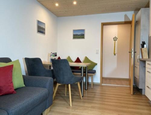 a living room with a couch and a table at Ferienhof Hefele Ferienwohnung Breitenberg mit KönigsCard in Hopferau