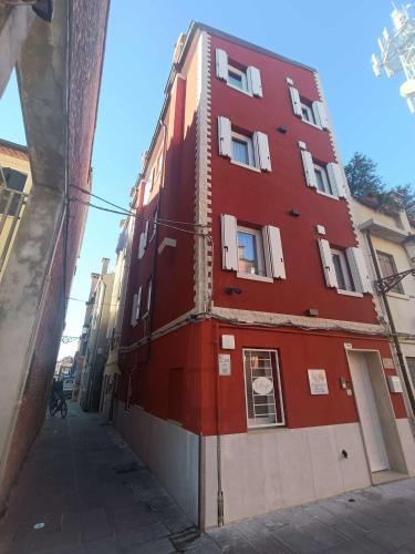 a red building on the side of a street at Dal Doge - Guest House in Chioggia