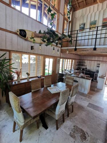 une grande salle à manger avec une table et des chaises en bois dans l'établissement Maison bois, entre ville et lac, à Lacanau