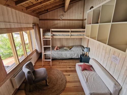 Cette chambre comprend un lit et une chaise. dans l'établissement Maison bois, entre ville et lac, à Lacanau