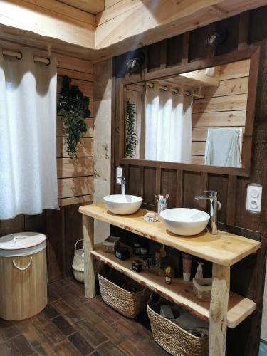 - une salle de bains avec deux lavabos sur un comptoir en bois dans l'établissement Maison bois, entre ville et lac, à Lacanau
