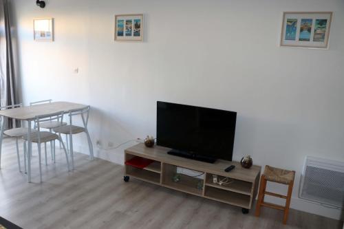 un salon avec une télévision et une table dans l'établissement Apt 4 couchages proche plage dans residence, au Cap d'Agde
