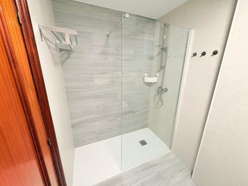 une douche avec une porte vitrée dans une salle de bain dans l'établissement Balcón de la ría de Ribadesella, à Ribadesella