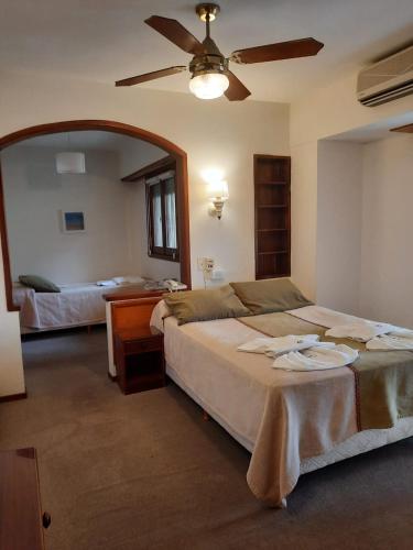 a bedroom with two beds and a ceiling fan at Hotel Riviera in Villa Gesell