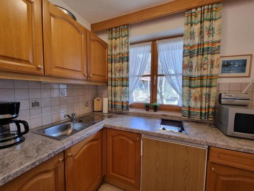 a kitchen with wooden cabinets and a sink and a microwave at Philipp -701- in Mittenwald