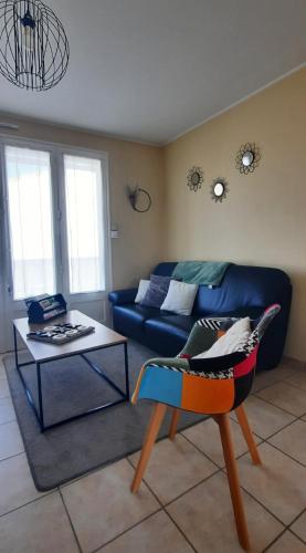 un salon avec un canapé bleu et une table dans l'établissement Ma maison au bord de la mer, à Saint-Hilaire-de-Riez