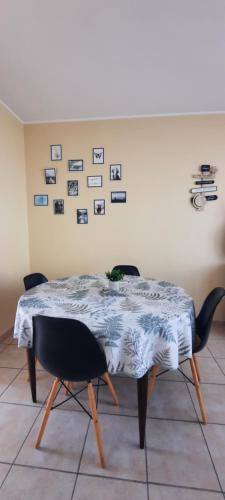 a dining room table with two chairs and pictures on the wall at Ma maison au bord de la mer in Saint-Hilaire-de-Riez