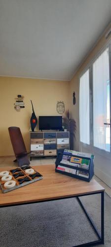 a living room with a coffee table and a television at Ma maison au bord de la mer in Saint-Hilaire-de-Riez