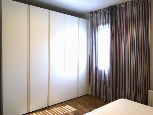 a bedroom with white cabinets and a window at Casa Gemma in Muggia