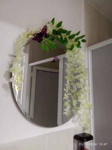 a mirror on a wall with flowers on it at KOKOA GARDEN INN in San Vicente de Chucurí