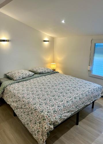 une chambre avec un lit avec un couvre-lit fleuri dans l'établissement Maison studio Le bois fleuri, à Croissy-Beaubourg