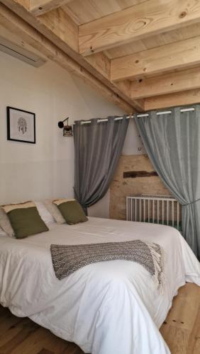 - une chambre avec un grand lit et des rideaux gris dans l'établissement La Grange Périgord - Sarlat - Piscine privée, à Archignac