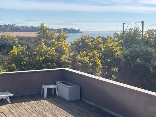 d'un balcon avec une table et un banc sur une terrasse. dans l'établissement 77 m3 2 chambres emplacement premium, à Agay