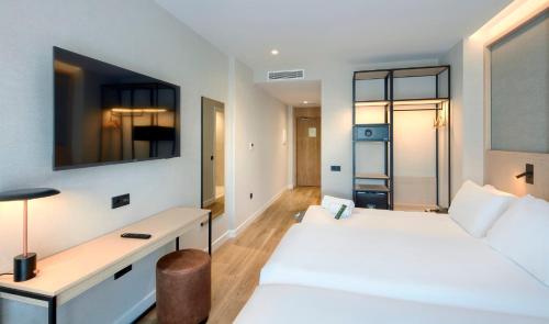Ένα ή περισσότερα κρεβάτια σε δωμάτιο στο Sercotel Rosaleda Málaga
