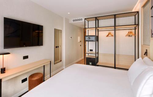 Ένα ή περισσότερα κρεβάτια σε δωμάτιο στο Sercotel Rosaleda Málaga
