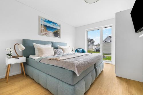 カッペルンにあるKerstins-Kleinod,Olpenitz-Resort,Kappeln, gratis Internet, Magenta-TV ,Parkplatz vor dem Haus, 300 Meter zum Strand,Infrarotsauna,ganz neuの青いベッドと窓のある寝室
