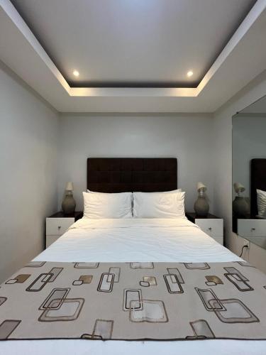 ein Schlafzimmer mit einem Bett mit einer großen weißen Bettdecke in der Unterkunft Sheryll Escapes - La Grande 406 cozy 1 bedroom Wi-Fi and Netflix in Angeles