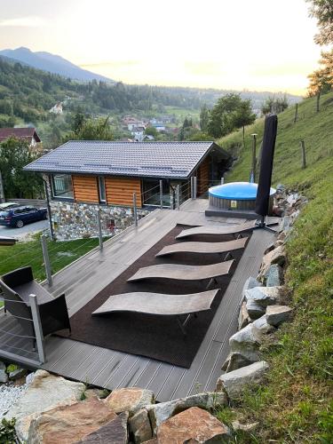 a wooden deck with a house with a swimming pool at Cabana Riky House in Statiunea Borsa