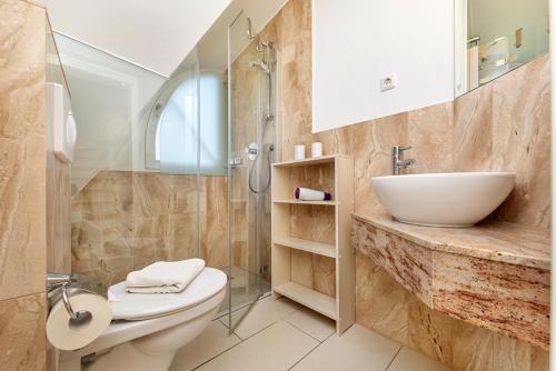 a bathroom with a sink and a toilet and a shower at Godeke Michels Ferienwohnung 23-Jonggöntje Seestr5b in Groß Kirr