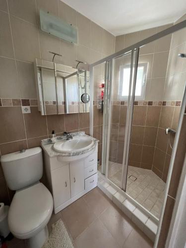 a bathroom with a shower and a toilet and a sink at Villa ensoleillée in Ifach