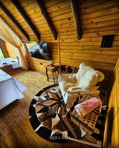 a room with a couch and a bed in a log cabin at Chalé Araucária in Bom Retiro