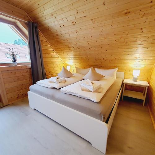 a bed in a room with a wooden wall at Ferienhaus Ostseeperle in Biendorf
