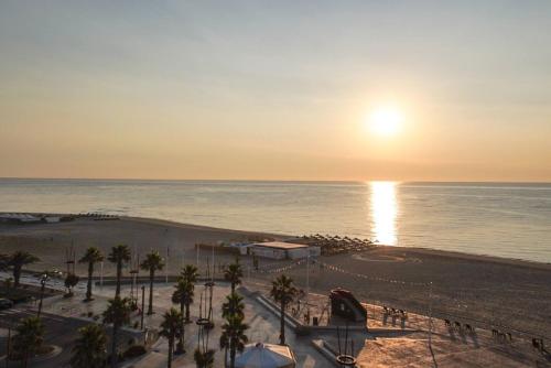 - une vue sur la plage au coucher du soleil dans l'établissement La Petite Mer-Veille avec vue mer et parking privé, à Canet